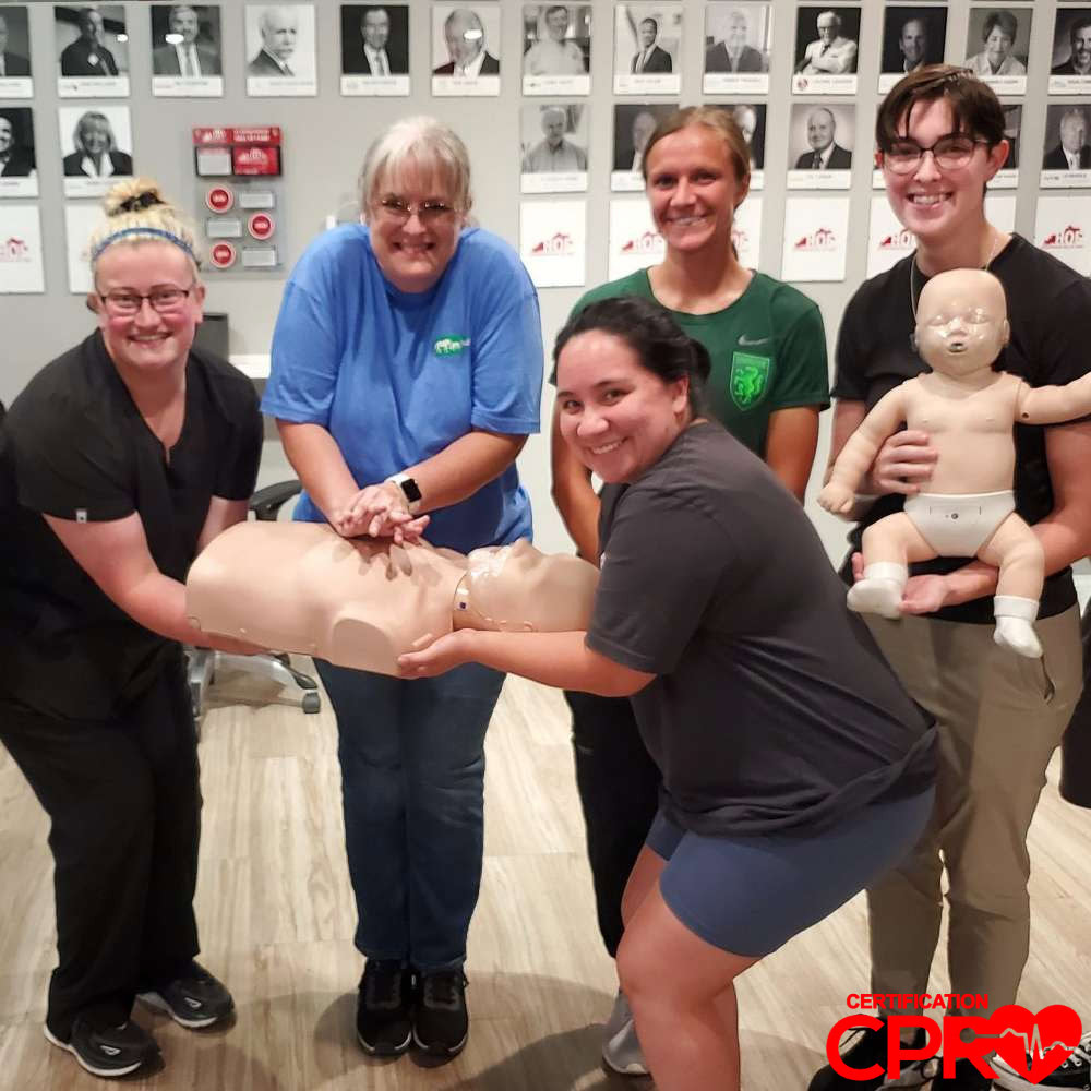 CPR training class in Baltimore with students practicing on mannequins.